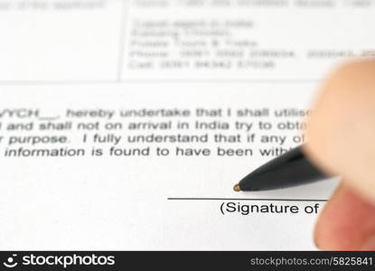 Businessman&rsquo;s hand with pen signing contract. Selective focus on top of pen.