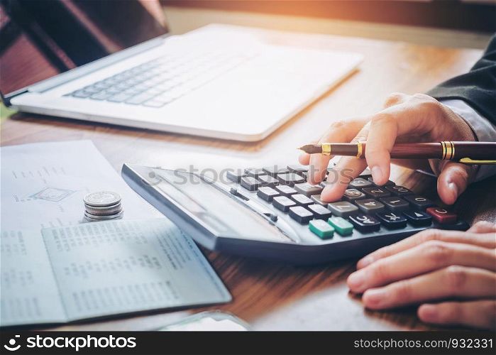 Businessman's hands with calculator and cost at the office and Financial data analyzing counting on wood desk