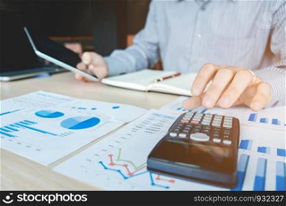 Businessman's hands with calculator at the office and Financial data analyzing counting