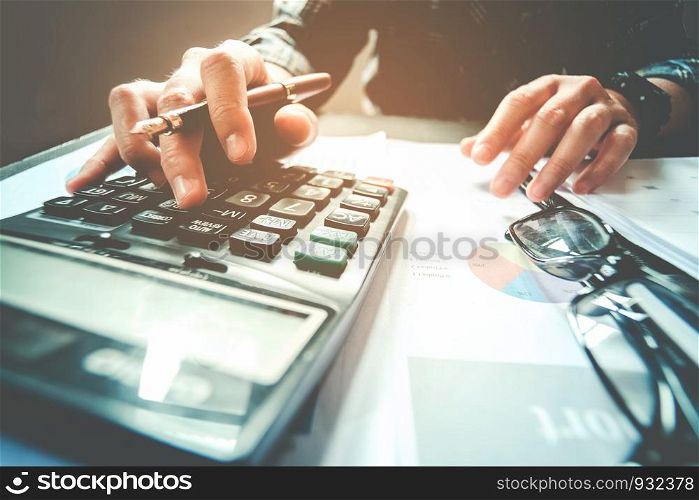 Businessman's hands with calculator at the office and Financial data Cost Economic
