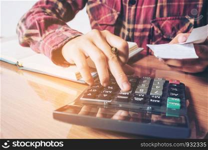 Businessman's hands with calculator counting making notes at home