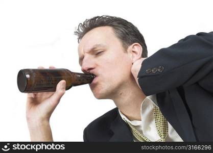 Businessman rubbing his neck while taking a sip of his beer