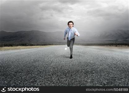 Businessman run on road. Young businessman in suit running outdoor on asphalt road