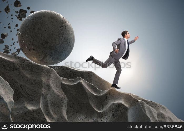 Businessman running away from falling rolling stone. The businessman running away from falling rolling stone