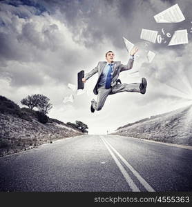 Businessman running on the road. Young businessman in suit running on the road