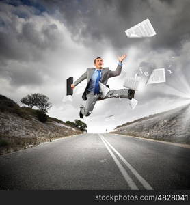 Businessman running on the road. Young businessman in suit running on the road