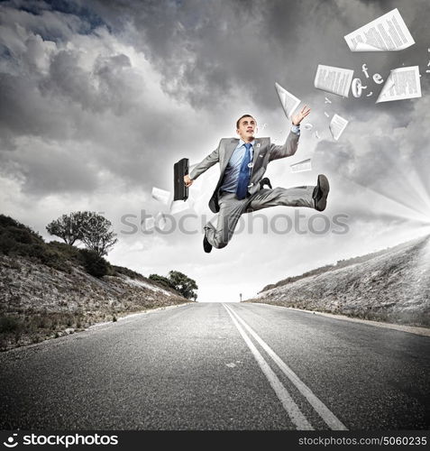 Businessman running on the road. Young businessman in suit running on the road