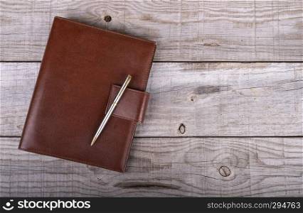 businessman’s agenda and pen on wooden background