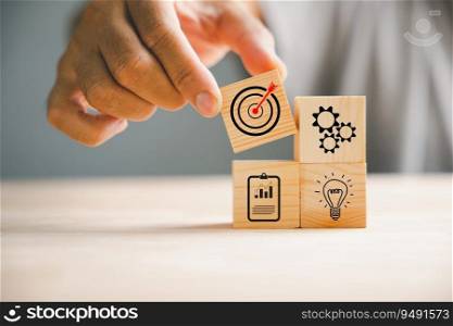 Businessman’s hand skillfully arranging wood blocks to illustrate a business strategy and Action plan. This concept emphasizes goal formation and objective achievement.