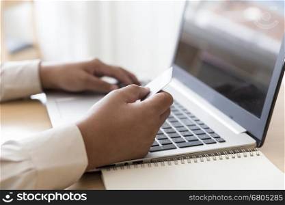 businessman's hand with laptop computer notebook and credit card for payment, shopping online concept