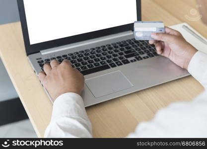 businessman's hand with laptop computer notebook and credit card for payment, shopping online concept