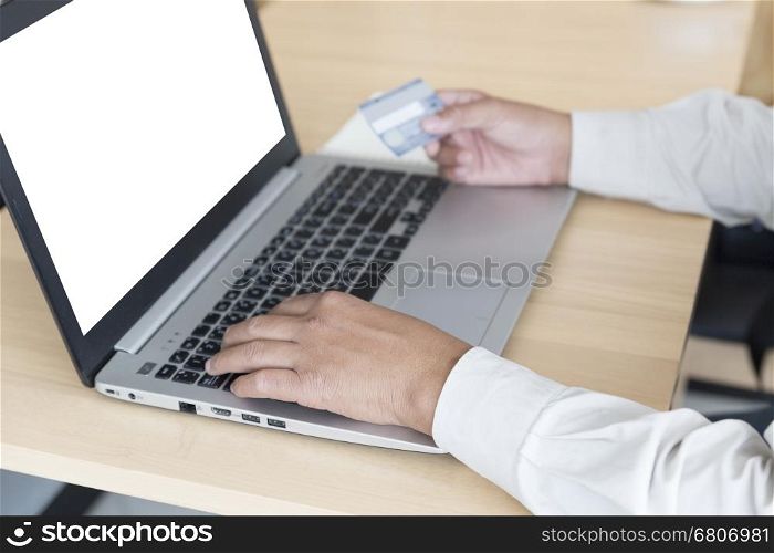 businessman's hand with laptop computer notebook and credit card for payment, shopping online concept