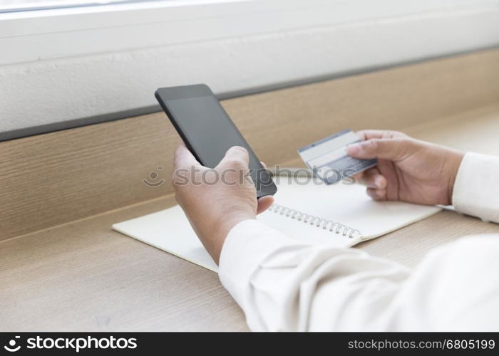 businessman's hand with mobile phone and credit card for payment, shopping online concept