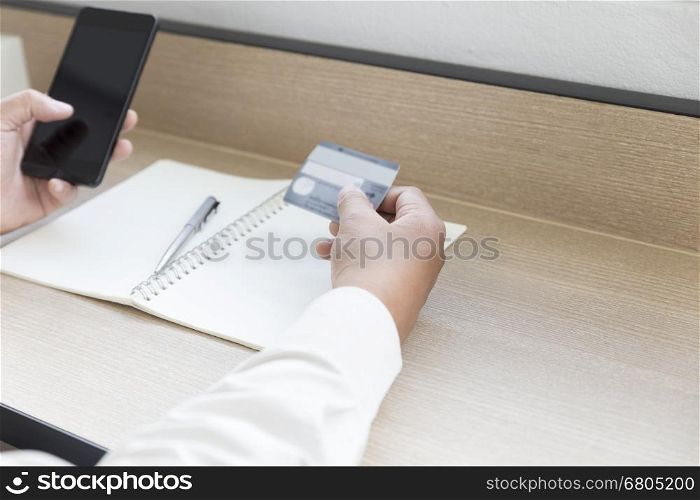 businessman's hand with mobile phone and credit card for payment, shopping online concept