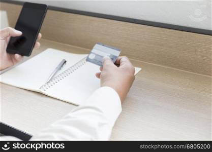 businessman's hand with mobile phone and credit card for payment, shopping online concept