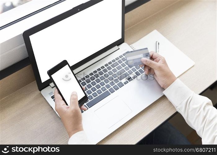businessman's hand with mobile phone, laptop computer and credit card for shopping online concept