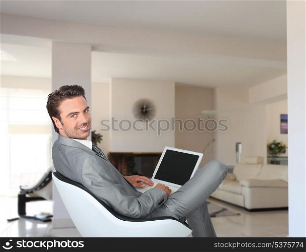 Businessman sat at home with laptop