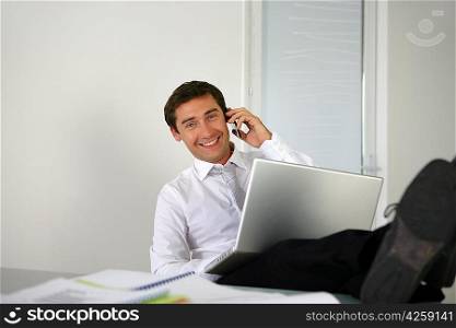 Businessman sat with his feet on the desk