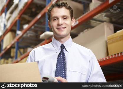 Businessman Scanning Package In Warehouse