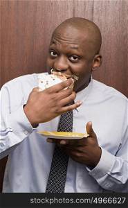 Businessman secretly eating cake