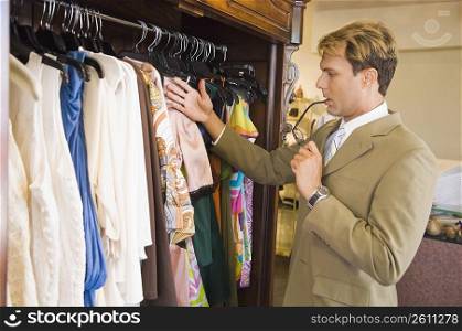 Businessman selecting dresses in a clothing store