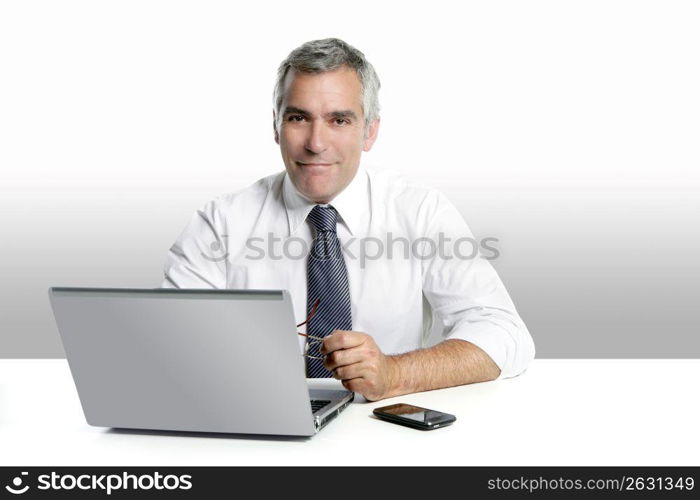 businessman senior gray hair working laptop computer white desk background