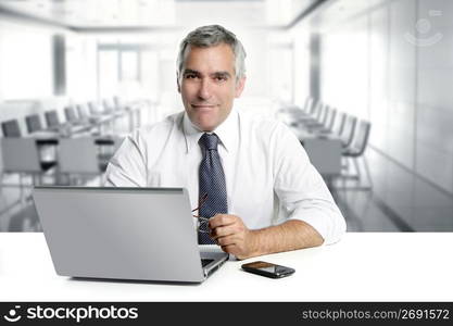 businessman senior gray hair working laptop interior modern white office