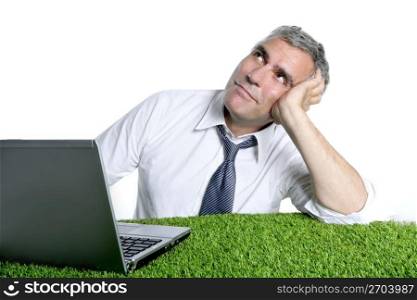 businessman senior relaxed on green grass desk ecology metaphor