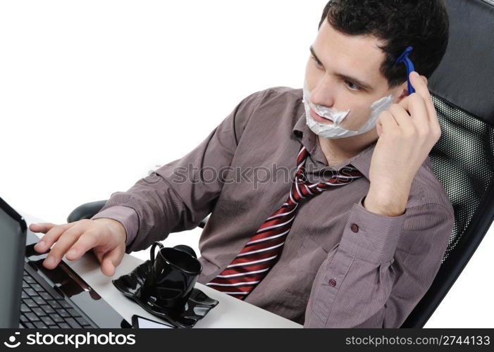 Businessman shaves in the workplace. Isolated on white background