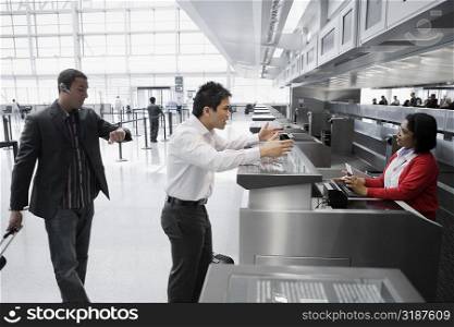 Businessman shouting at an airline check-in attendant