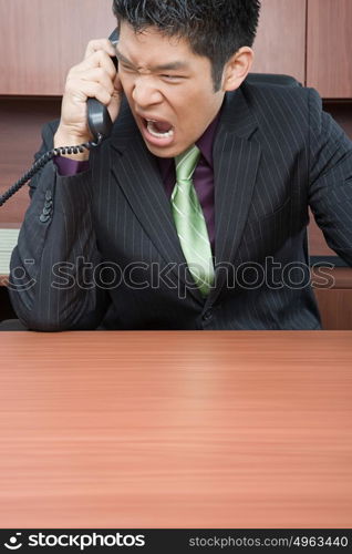 Businessman shouting down phone