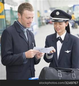 Businessman showing an airplane ticket to a female pilot