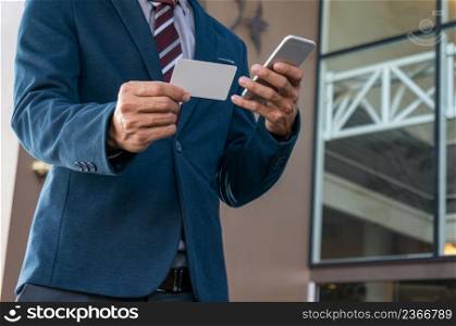 Businessman showing blank business card and holding smart phone.Business man holding white blank card space for text. product display