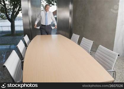 Businessman showing empty pockets in a board room