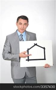 Businessman showing for sale sign