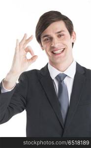 Businessman showing ok sign. Everything is OK! Happy young business man in suit and tie gesturing OK sign and smiling standing isolated on white background