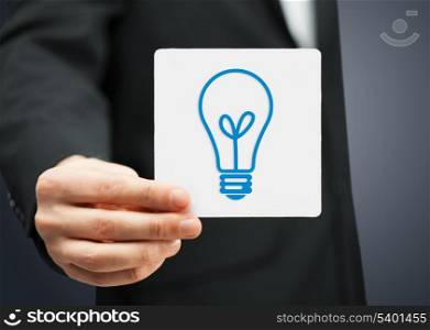 businessman showing sheet with sign of light bulb