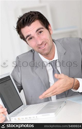 Businessman showing something on laptop computer