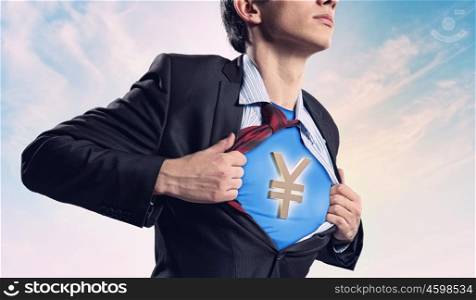 Businessman showing superman suit underneath shirt. Image of young businessman in superhero suit with yen sign on chest