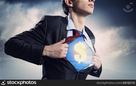 Businessman showing superman suit underneath shirt. Image of young businessman in superhero suit with dollar sign on chest