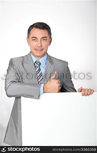 Businessman showing white message board