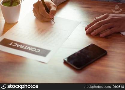 Businessman signing a document in office