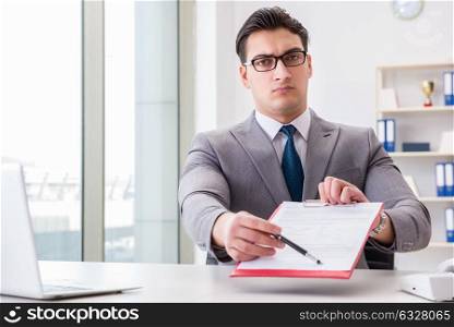 Businessman signing business documents in office. The businessman signing business documents in office