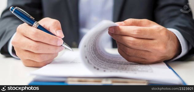 Businessman signing on contract documents after reading, man holding pen and approve on business report. Contract agreement, partnership and deal concepts