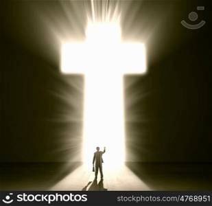 Businessman silhouette. Silhouette of businessman against cross in light