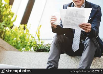 businessman sit and reading data resource outdoor with coffee.