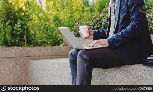businessman sit and working on laptop about data resource outdoor with coffee.