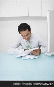 Businessman sitting at a desk and looking at documents in an office