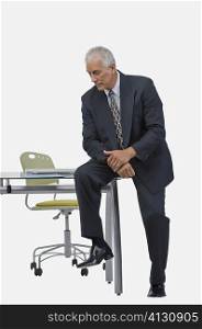 Businessman sitting at a desk in an office and thinking