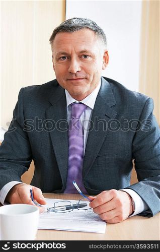 Businessman sitting at desk in office portrait